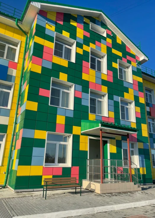 Зелёные, жёлтые и розовые кассеты в облицовке фасада.